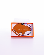 Hermes Petit H Rat bag charm crafted from orange leather.