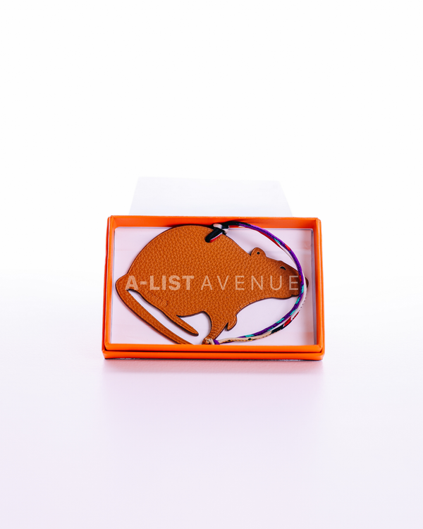 Hermes Petit H Rat bag charm crafted from orange leather.