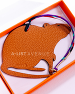 Hermes Petit H Rat bag charm crafted from orange leather.